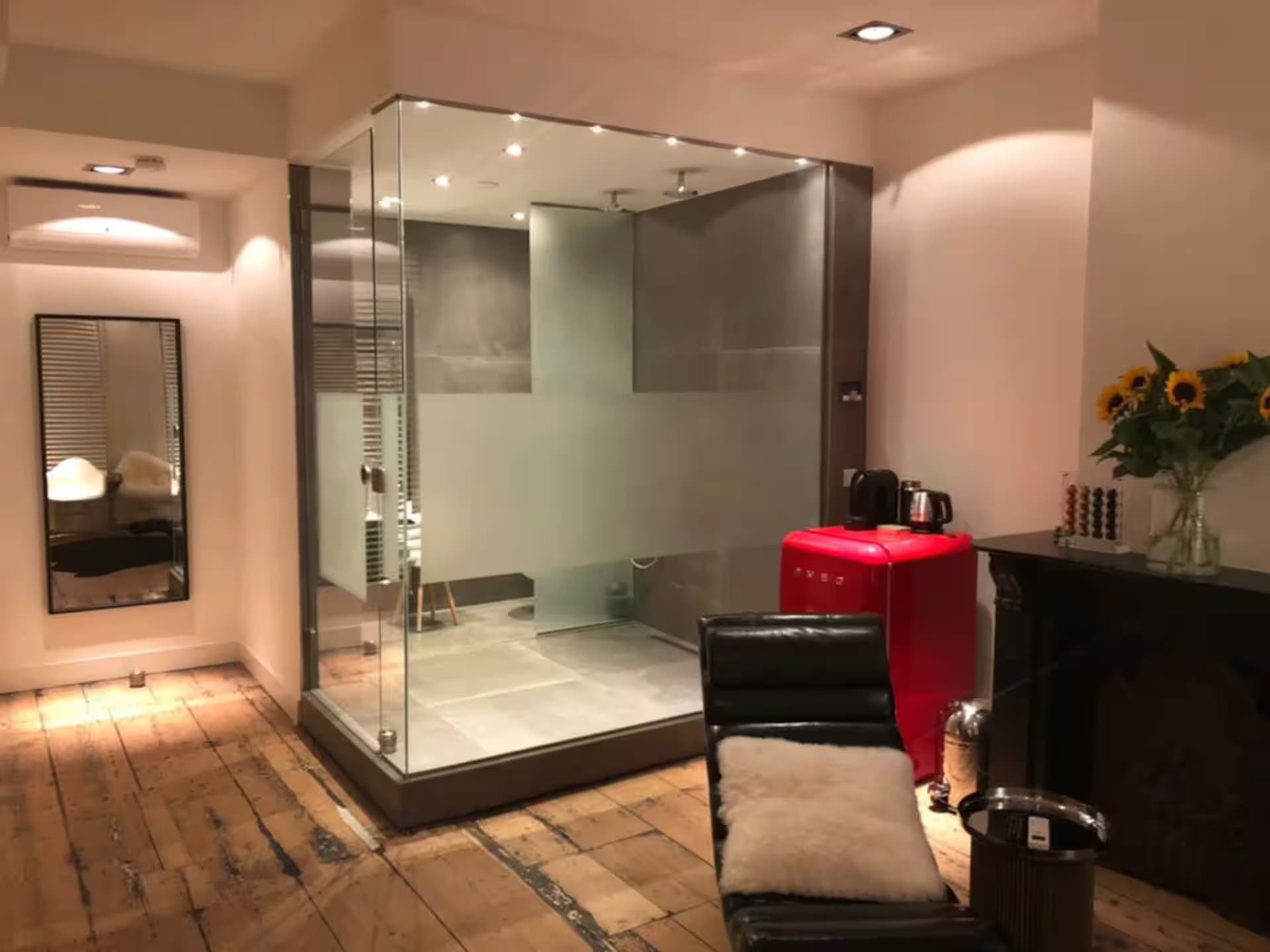 Double Fun — verlichte stoomdouche-cabine van glas met houten vloer en rode Smeg mini-koelkast
