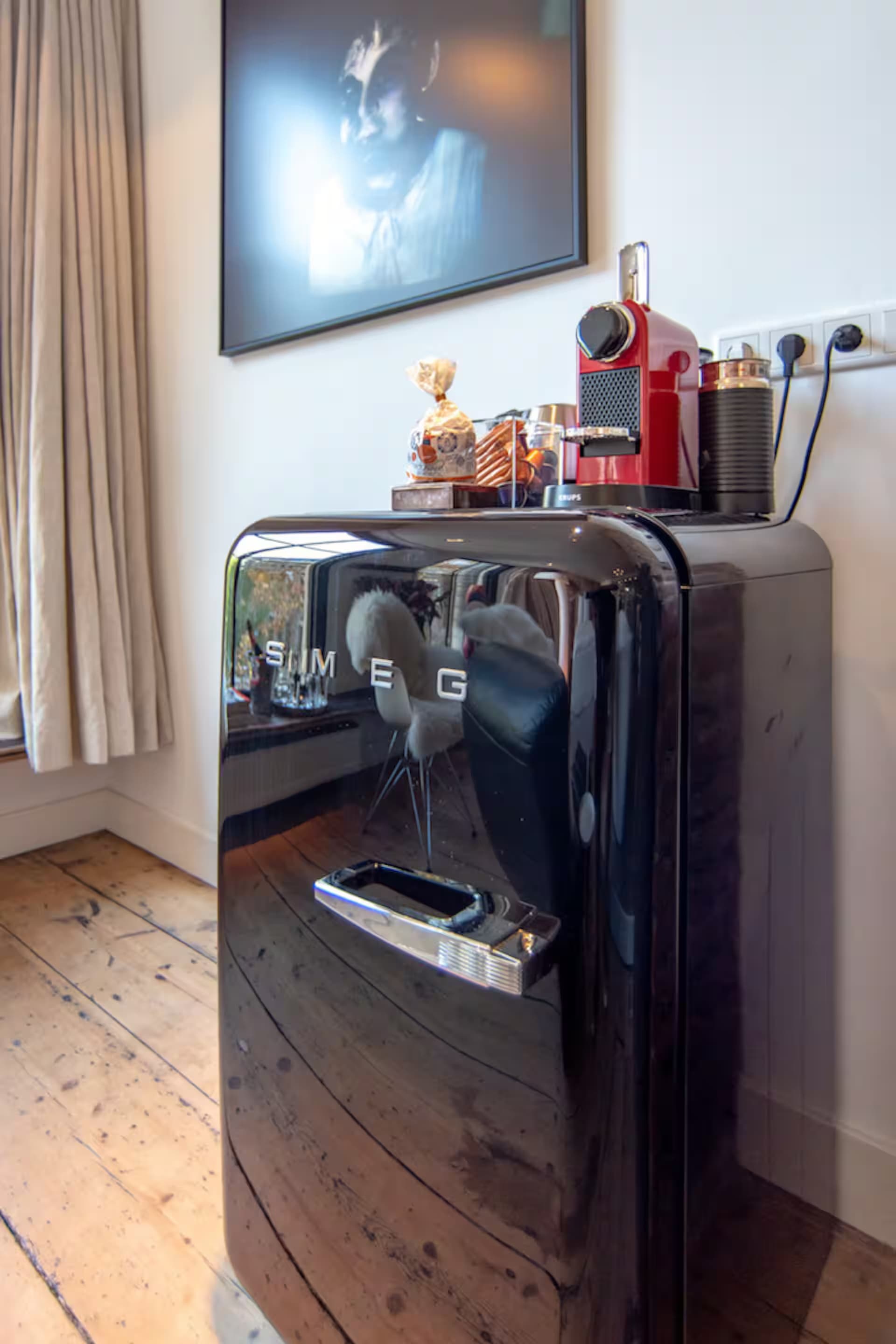 Love Suite — Nespresso-machine en zwarte Smeg mini-koelkast onder kunst aan de muur